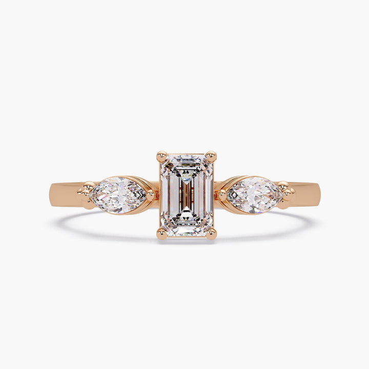 14k rose gold emerald cut and pear diamond ring on white background