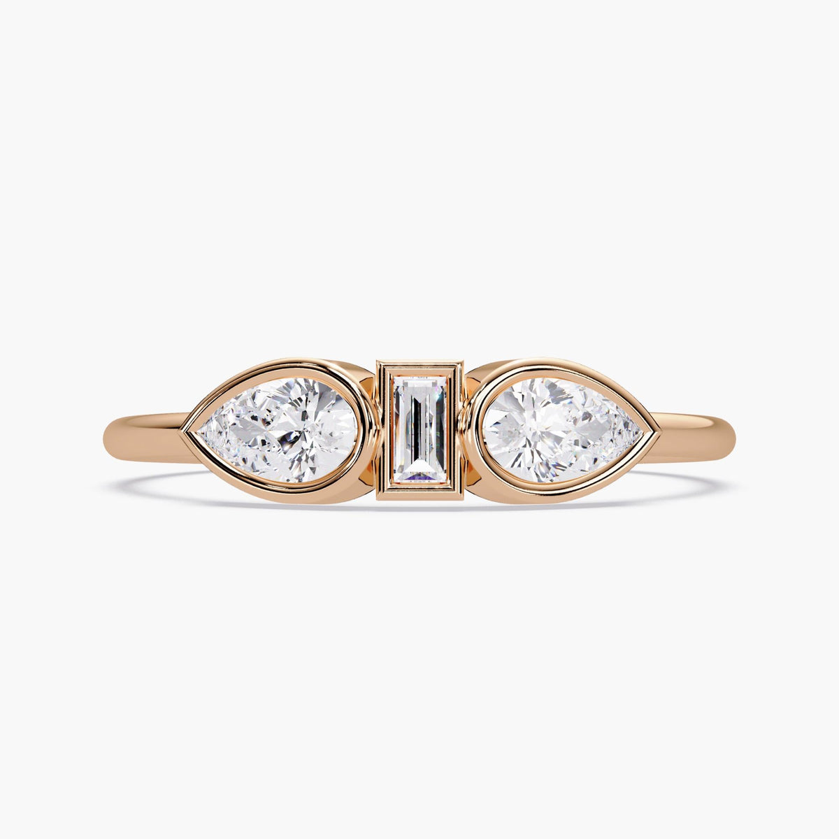 May include: A gold ring with three diamonds. The center diamond is a rectangular emerald cut, and the two diamonds on either side are pear shaped.