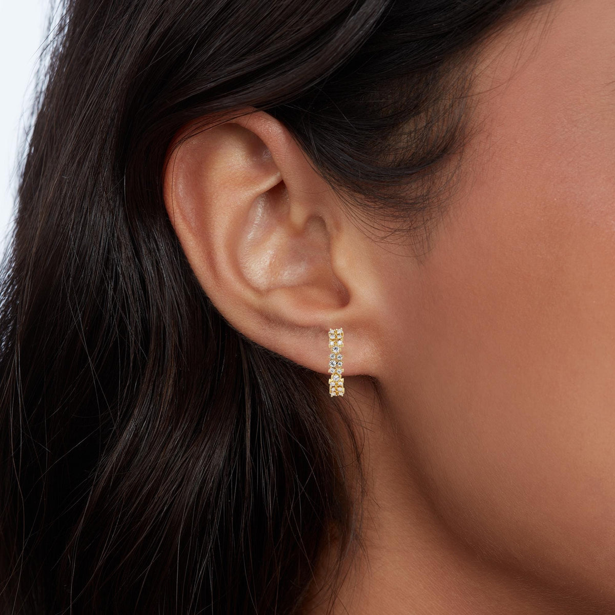 14K gold diamond cluster half hoop earrings showing curved design and prong-set diamonds.
