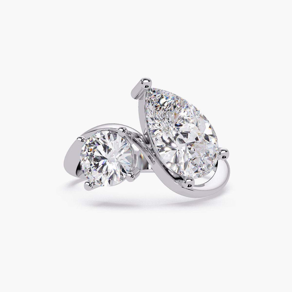 14k white gold toi et moi ring with a pear diamond and round diamond in a bypass design.