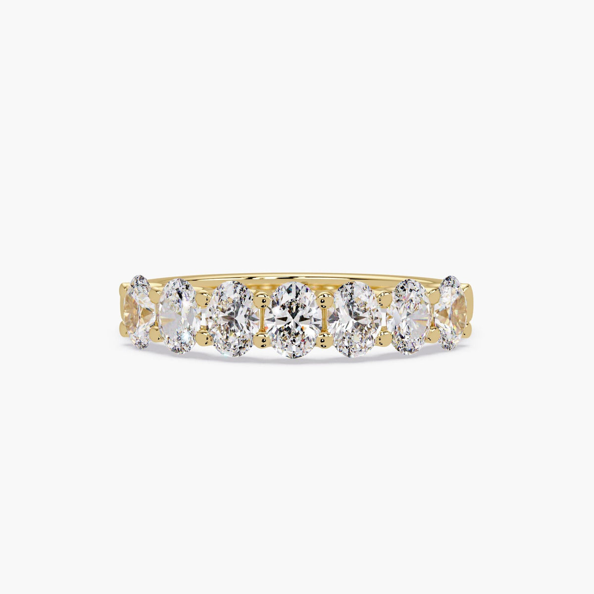 Oval lab grown diamond band in 14K yellow gold featuring seven prong-set oval diamonds arranged across the top of the ring.