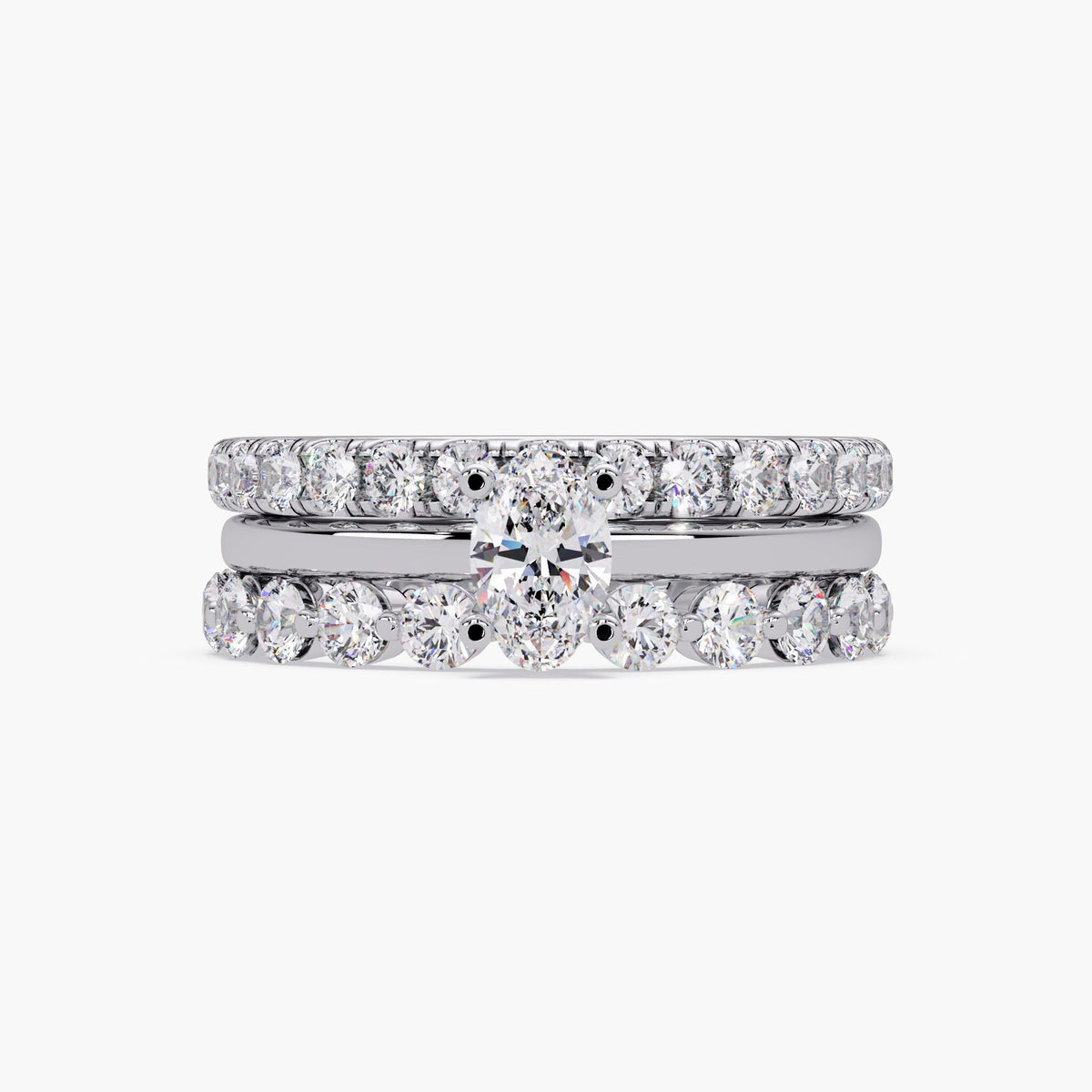 Oval lab grown diamond engagement ring set in 14K white gold, featuring an oval solitaire center ring stacked with two round diamond bands for a bridal or stacking ring look.