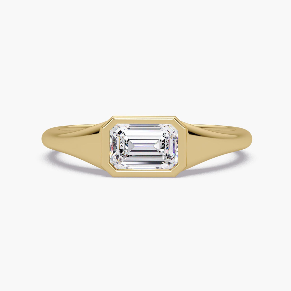 Emerald cut lab diamond signet ring in 14K yellow gold with a bezel-set center stone and smooth tapered band, styled as a modern pinky or statement ring for everyday wear.