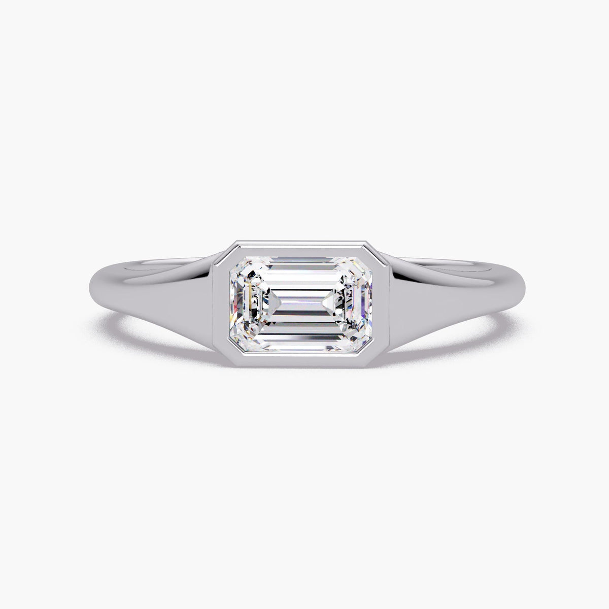 Emerald cut lab diamond signet ring in 14K white gold with a bezel-set center stone and smooth tapered band, styled as a modern pinky or statement ring for everyday wear.