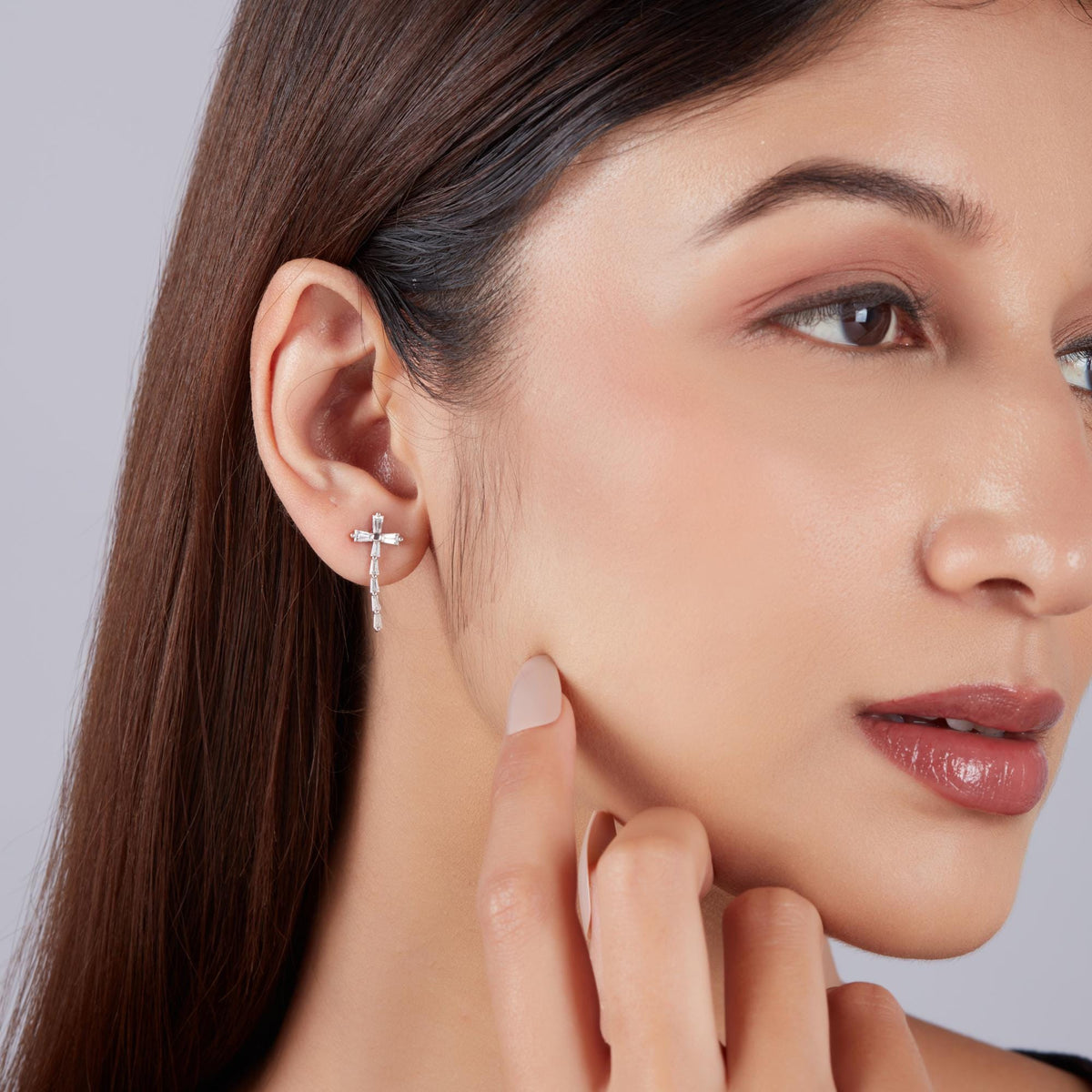 Baguette lab diamond cross earrings on ear in solid gold