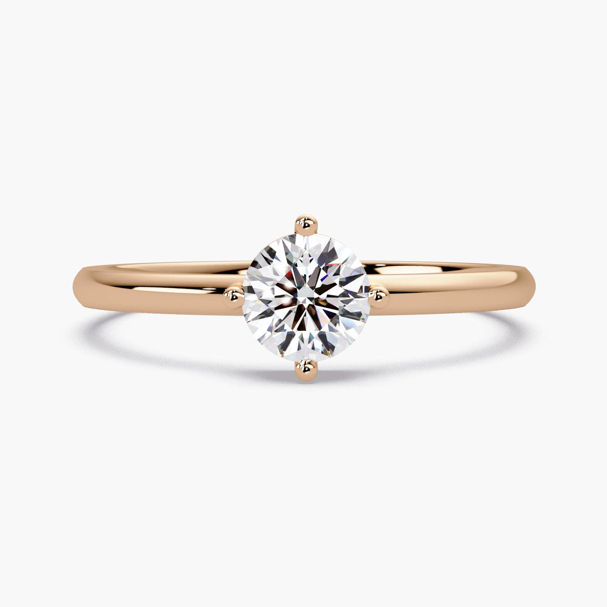 0.50 CT round lab grown diamond solitaire engagement ring in 14K rose gold with four prong setting and thin 1.5mm band.