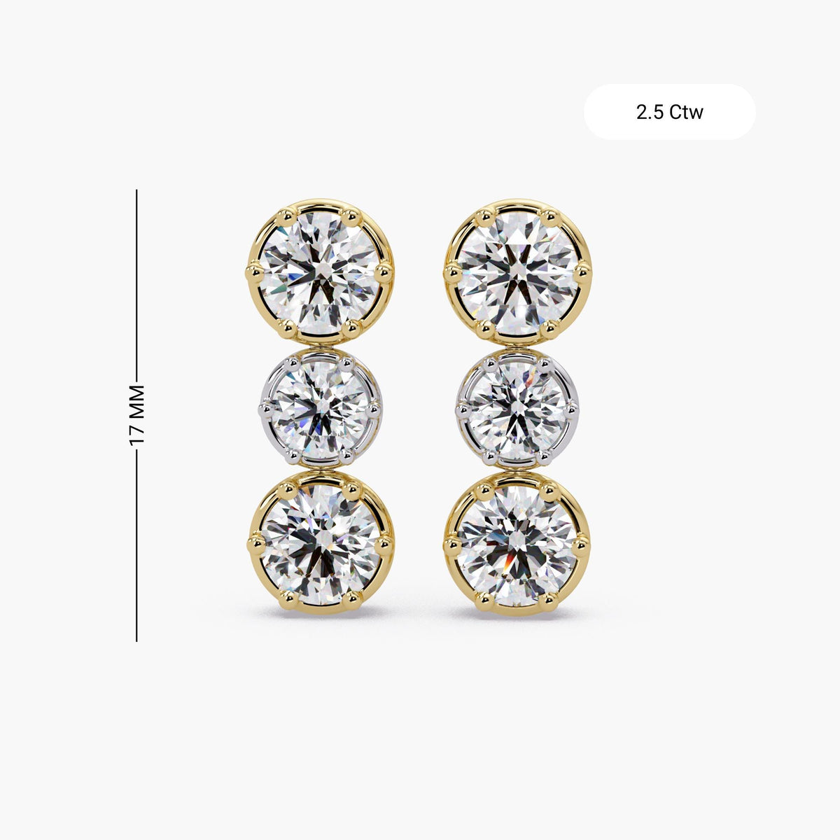 Vertical mixed metal diamond drop stud earrings worn on ear, featuring three round lab-grown diamonds in two-tone gold crown settings