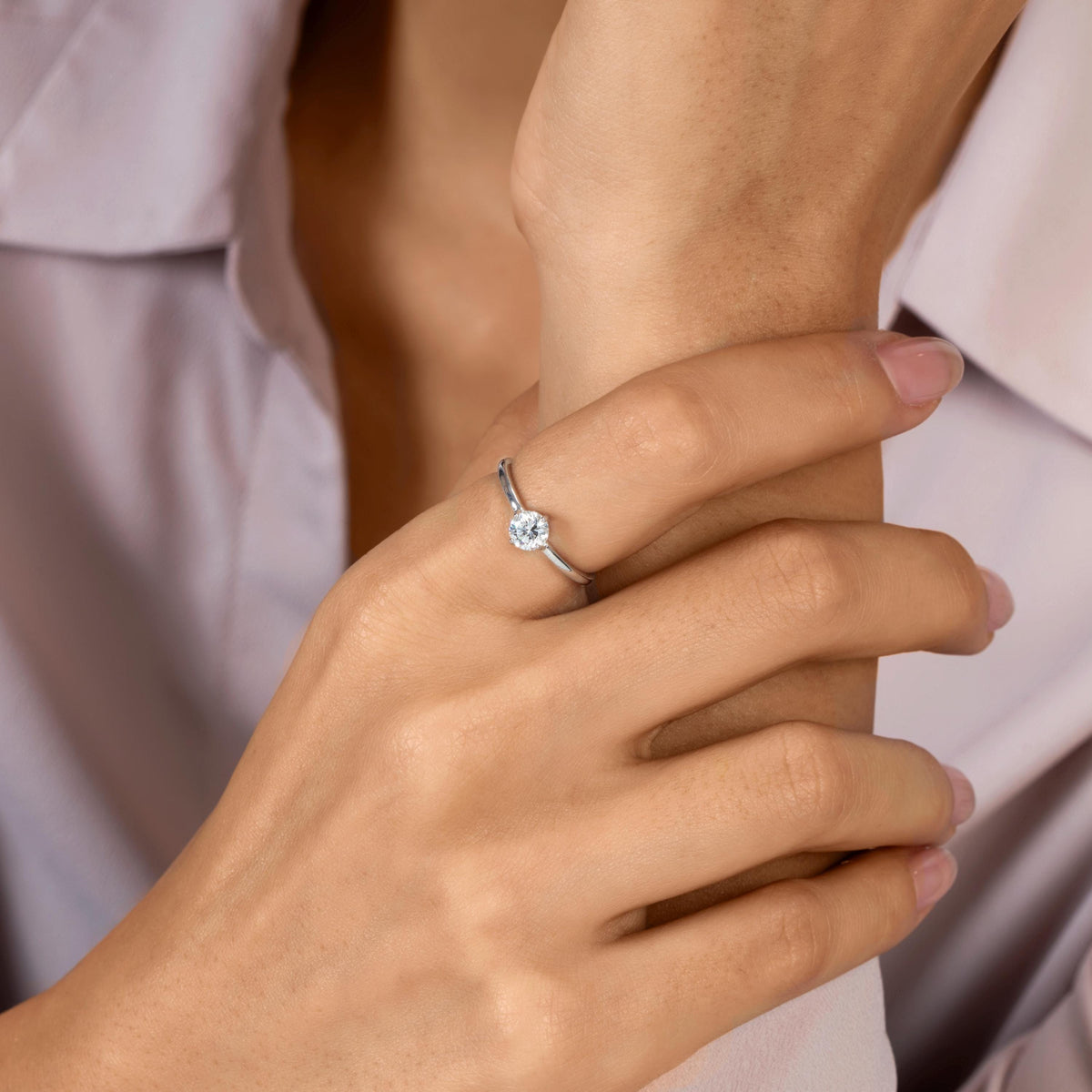 0.50 ct round lab-grown diamond solitaire ring in 14K gold with a four-prong setting and slim 1.5 mm band, worn on a hand.