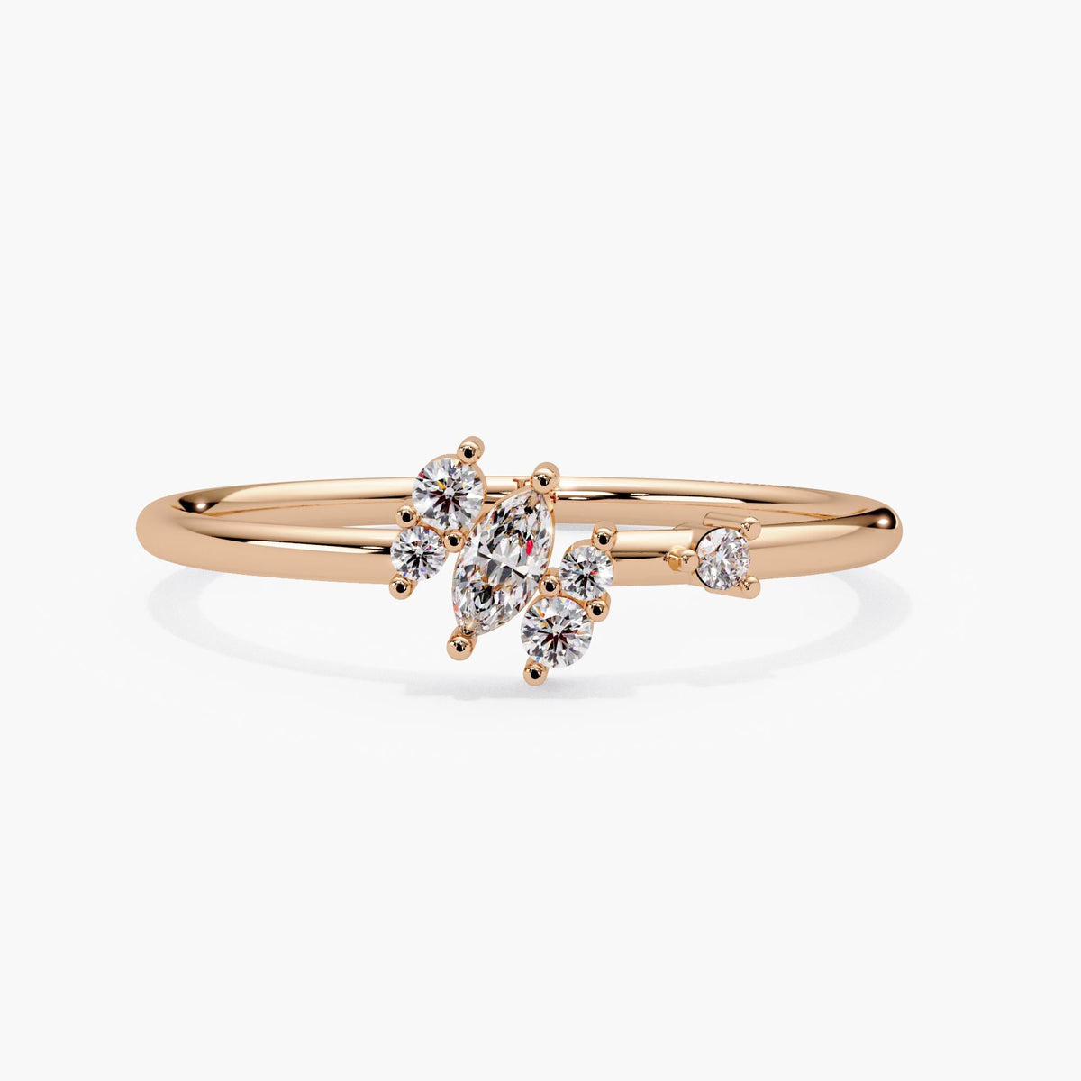 14k rose gold marquise diamond cluster ring at an angle, with one marquise and five round lab grown diamonds on a dainty band.