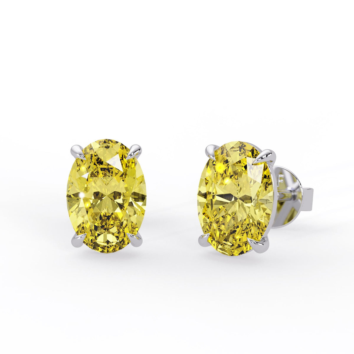 Oval fancy intense yellow lab grown diamond stud earrings in 14K white gold with four claw prongs and pushback closures.