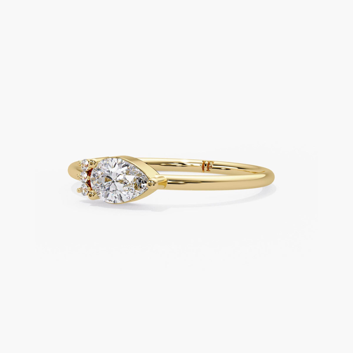 14k yellow gold horizontal pear ring, the teardrop diamond prong set east to west with three bezel set rounds on one shoulder.