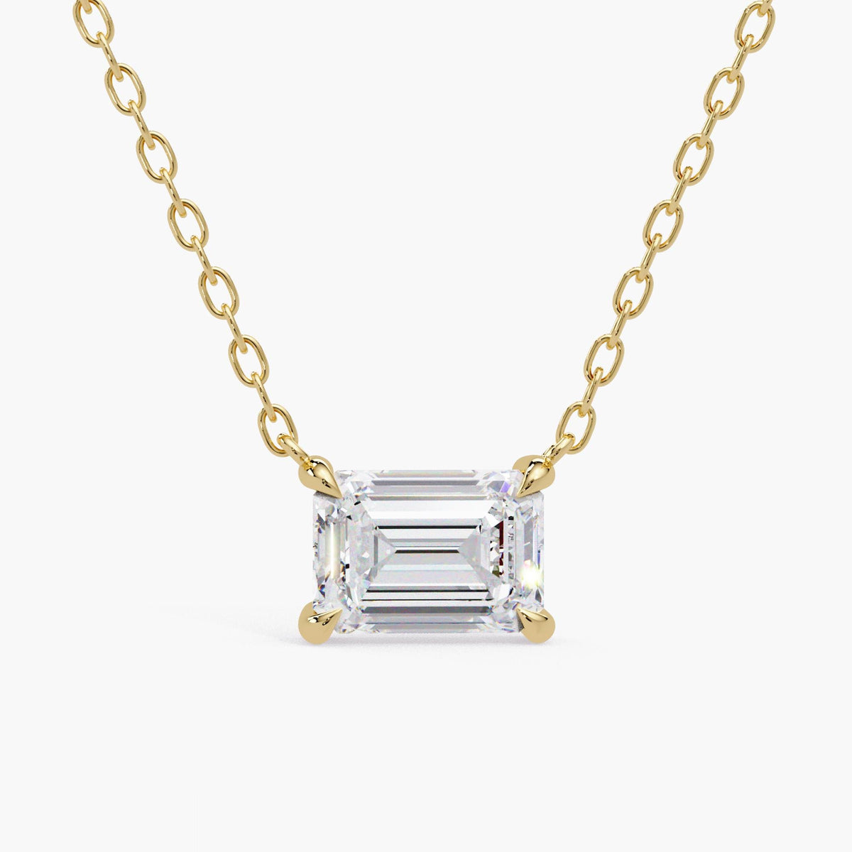Emerald-cut lab-grown diamond necklace in 14K yellow gold, with the rectangular stone set horizontally in four prongs claw setting. 18 inch cable chain